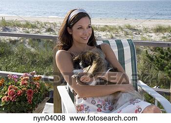 Stock Photo - woman holding 
dog on deck near 
beach. fotosearch 
- search stock 
photos, pictures, 
images, and photo 
clipart