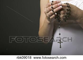 Stock Photo - woman holding 
rosary. fotosearch 
- search stock 
photos, pictures, 
images, and photo 
clipart