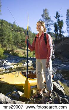 Picture - woman with oar 
and kayak by craggy 
stream. fotosearch 
- search stock 
photos, pictures, 
images, and photo 
clipart