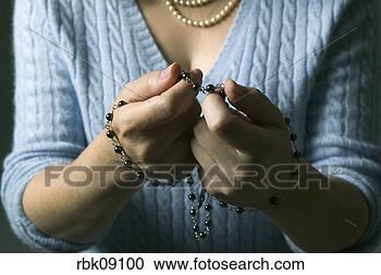 Stock Photography - woman praying 
with rosary beads. 
fotosearch - search 
stock photos, 
pictures, images, 
and photo clipart