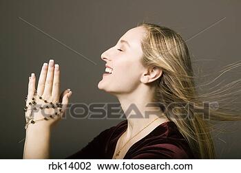 Stock Photo - woman praying 
with rosary beads. 
fotosearch - search 
stock photos, 
pictures, images, 
and photo clipart