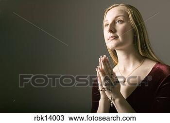 Stock Photo - woman praying 
with rosary beads. 
fotosearch - search 
stock photos, 
pictures, images, 
and photo clipart