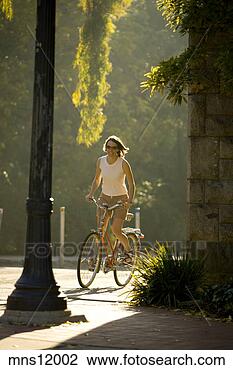 Stock Photo - woman riding a 
bike on college 
campus. fotosearch 
- search stock 
photos, pictures, 
images, and photo 
clipart