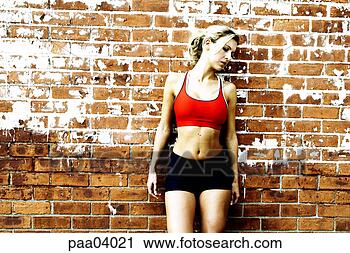 Stock Photography - woman runner resting 
against brick 
wall. fotosearch 
- search stock 
photos, pictures, 
images, and photo 
clipart