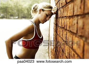 Stock Photo - woman runner resting 
against brick 
wall. fotosearch 
- search stock 
photos, pictures, 
images, and photo 
clipart