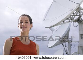 Stock Photography - woman standing 
near large satellite 
dish. fotosearch 
- search stock 
photos, pictures, 
images, and photo 
clipart