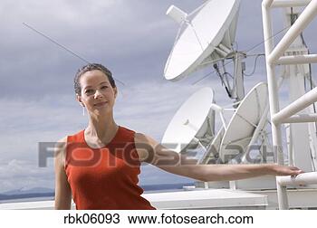 Stock Photo - woman standing 
near large satellite 
dish. fotosearch 
- search stock 
photos, pictures, 
images, and photo 
clipart