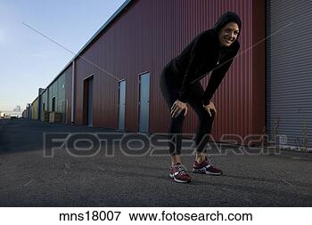 Picture - young adult woman 
resting near warehouse. 
fotosearch - search 
stock photos, 
pictures, images, 
and photo clipart