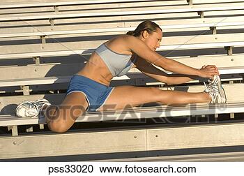 Stock Photography - young adult woman 
stretching on 
bleachers. fotosearch 
- search stock 
photos, pictures, 
images, and photo 
clipart