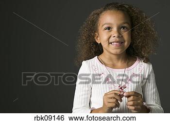 Stock Photo - young african 
girl smiling with 
jeweled cross. 
fotosearch - search 
stock photos, 
pictures, images, 
and photo clipart