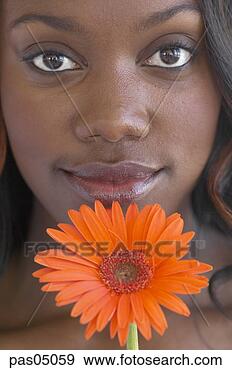 Stock Photograph - young african 
woman with flower. 
fotosearch - search 
stock photos, 
pictures, images, 
and photo clipart