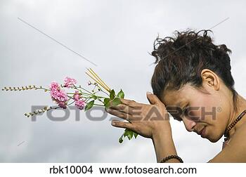 Stock Photo - young asian woman 
praying and holding 
flowers. fotosearch 
- search stock 
photos, pictures, 
images, and photo 
clipart