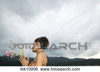 Stock Photo - young asian woman 
praying and holding 
flowers. fotosearch 
- search stock 
photos, pictures, 
images, and photo 
clipart