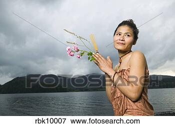 Picture - young asian woman 
praying and holding 
flowers. fotosearch 
- search stock 
photos, pictures, 
images, and photo 
clipart