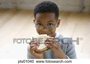Stock Photography - young boy wearing 
glasses eating 
sandwich. fotosearch 
- search stock 
photos, pictures, 
images, and photo 
clipart