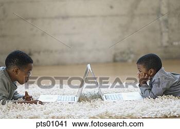 Stock Photography - young boys using 
laptops on shag 
rug. fotosearch 
- search stock 
photos, pictures, 
images, and photo 
clipart