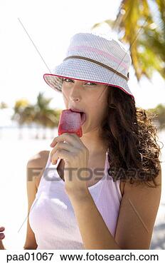 Picture - young hispanic 
woman eating a 
popsicle. fotosearch 
- search stock 
photos, pictures, 
images, and photo 
clipart