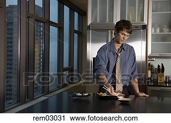 Stock Photography - young man eating 
sushi in kitchen. 
fotosearch - search 
stock photos, 
pictures, images, 
and photo clipart