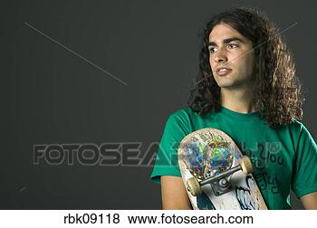 Stock Photo - young man holding 
skateboard with 
religious sticker. 
fotosearch - search 
stock photos, 
pictures, images, 
and photo clipart