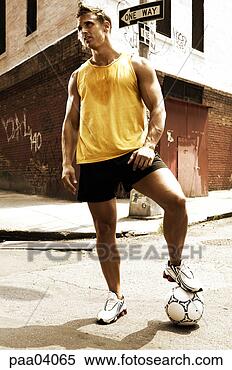 Stock Image - young man with 
soccer ball on 
urban street. 
fotosearch - search 
stock photos, 
pictures, images, 
and photo clipart
