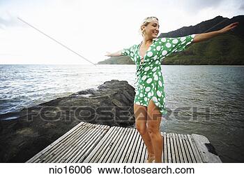 Stock Photo - young woman with 
arms outstretched 
on dock. fotosearch 
- search stock 
photos, pictures, 
images, and photo 
clipart