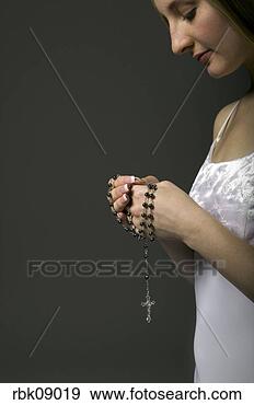 Stock Photograph - young woman holding 
rosary. fotosearch 
- search stock 
photos, pictures, 
images, and photo 
clipart