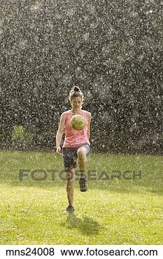 Stock Photo - young woman kicking 
soccer ball in 
rain. fotosearch 
- search stock 
photos, pictures, 
images, and photo 
clipart