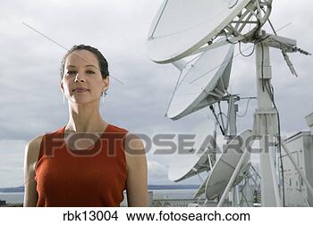 Stock Photo - young woman standing 
by satellite. 
fotosearch - search 
stock photos, 
pictures, images, 
and photo clipart