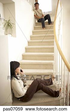 Stock Photograph - young woman talking 
on telephone at 
bottom of stairs. 
fotosearch - search 
stock photos, 
pictures, images, 
and photo clipart