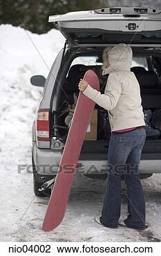 Stock Photo - young woman unloading 
a snowboard from 
her trunk. fotosearch 
- search stock 
photos, pictures, 
images, and photo 
clipart
