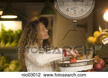 Stock Photo - young woman weighing 
tomatoes. fotosearch 
- search stock 
photos, pictures, 
images, and photo 
clipart