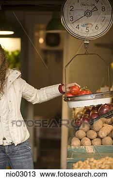 Stock Photo - young woman weighing 
tomatoes. fotosearch 
- search stock 
photos, pictures, 
images, and photo 
clipart