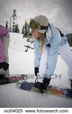 Stock Image - young women strapping 
boots to snowboards. 
fotosearch - search 
stock photos, 
pictures, images, 
and photo clipart