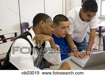 Stock Photograph - african and hispanic 
teenagers working 
on laptop in classroom. 
fotosearch - search 
stock photos, 
pictures, images, 
and photo clipart