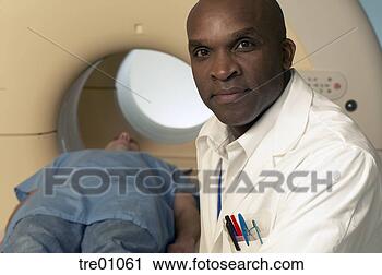 Stock Photography - african male doctor 
supervising patient 
in scanner. fotosearch 
- search stock 
photos, pictures, 
images, and photo 
clipart