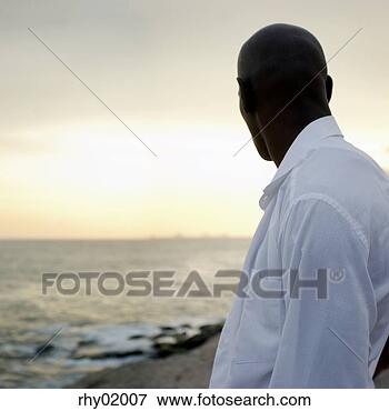 Picture - african man looking 
out over water. 
fotosearch - search 
stock photos, 
pictures, images, 
and photo clipart