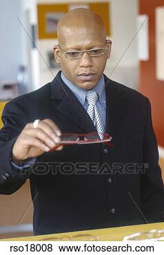 Stock Photo - african man shopping 
for eyeglasses. 
fotosearch - search 
stock photos, 
pictures, images, 
and photo clipart