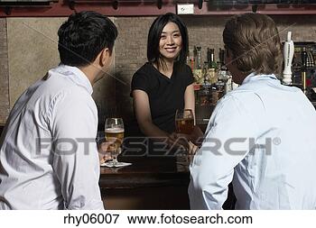 Picture - asian female bartender 
serving two men 
at bar. fotosearch 
- search stock 
photos, pictures, 
images, and photo 
clipart