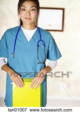 Picture - asian female nurse 
holding clipboard. 
fotosearch - search 
stock photos, 
pictures, images, 
and photo clipart