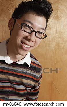 Stock Photo - asian man smiling 
in front of wall. 
fotosearch - search 
stock photos, 
pictures, images, 
and photo clipart