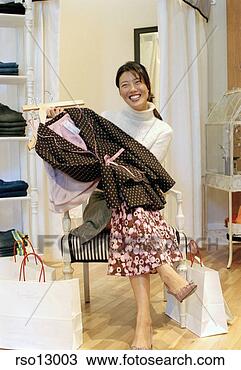 Stock Photo - asian woman holding 
clothes. fotosearch 
- search stock 
photos, pictures, 
images, and photo 
clipart