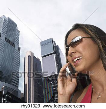 Stock Photograph - asian woman talking 
on cell phone 
by skyscrapers. 
fotosearch - search 
stock photos, 
pictures, images, 
and photo clipart