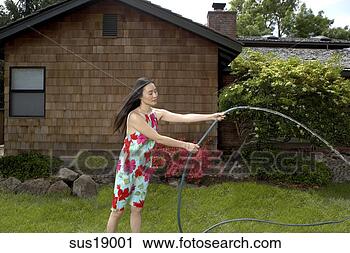 Stock Photography - asian woman watering 
plants. fotosearch 
- search stock 
photos, pictures, 
images, and photo 
clipart