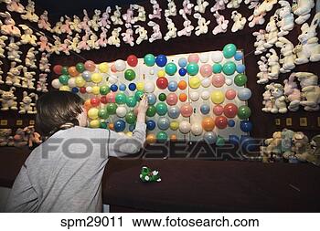 Stock Photography - boy at carnival 
booth throwing 
darts at balloons. 
fotosearch - search 
stock photos, 
pictures, images, 
and photo clipart
