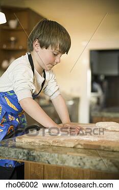 Stock Photo - boy kneading dough 
on wooden board 
in kitchen. fotosearch 
- search stock 
photos, pictures, 
images, and photo 
clipart