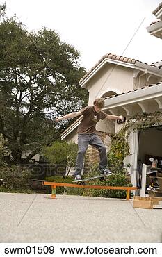 Stock Photograph - boy playing on 
skateboard in 
driveway. fotosearch 
- search stock 
photos, pictures, 
images, and photo 
clipart