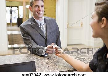 Stock Photo - businessman paying 
at hotel front 
desk. fotosearch 
- search stock 
photos, pictures, 
images, and photo 
clipart