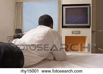 Stock Photography - businessman watching 
television on 
bed. fotosearch 
- search stock 
photos, pictures, 
images, and photo 
clipart