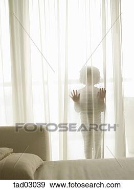 Stock Photograph - child hiding behind 
sheer curtains. 
fotosearch - search 
stock photos, 
pictures, images, 
and photo clipart