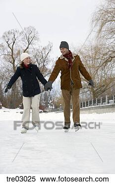 Stock Image - couple ice skating 
hand-in-hand. 
fotosearch - search 
stock photos, 
pictures, images, 
and photo clipart